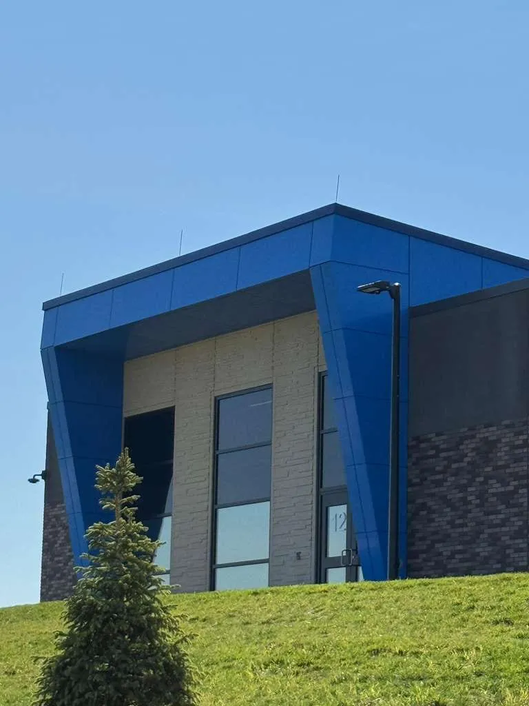 Iron Bluff Elementary — Blue ACM at both entrances — columns, fascias, soffits and transitions — plus Morin wall panel at the rooftop walls. (5/8)